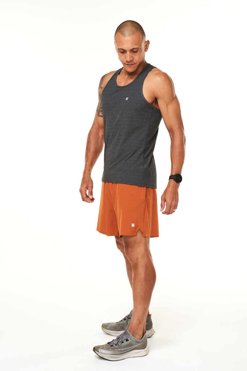 Left view of rust Rep Shorts. Men's workout shorts with a 7" inseam.