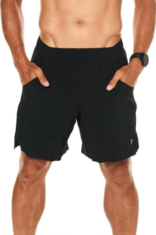 Model with his hands in the pockets of black Rep Shorts. Men's gym shorts that double as casual wear.