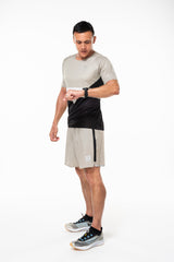 Left view men's Noosa Run Short. Tan run shorts with vertical black stripe and reflective logo.