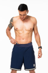 Model placing keys in small waistline pocket of Arvo Shorts. Navy running shorts with pockets.
