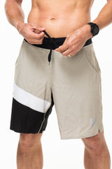 Model tying drawstring in sand/black Arvo Shorts. Workout shorts with comfortable and adjustable waistline.