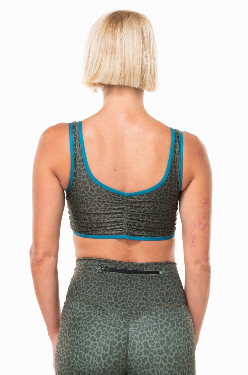 Back view of women's EcoActive reversible bralette. Dark green animal print sports bra.
